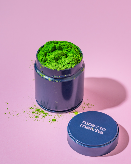 Nice To Matcha Masters Reserve tin on pink background with matcha powder